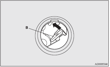 2. Move the lever (B) up to open the tailgate.