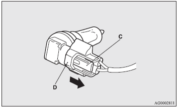 3. While holding down the tab (C), pull out the socket (D).